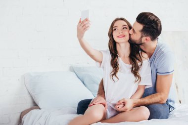 erkek kız yatak odasında selfie çekerken öpüşme