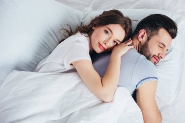 Genç sevgi dolu kız arkadaşım nazik kucaklayan erkek yatakta