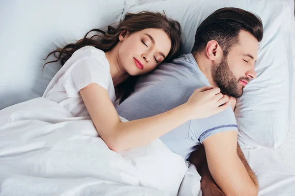 Jovem Casal Dormindo Cama Branca Macia Quarto Enquanto Mulher Abraçando — Fotografia de Stock