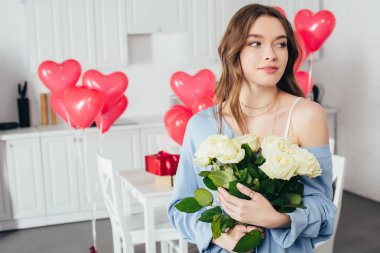 seçici odak Oda kalp şeklinde balonlarla süslenmiş gül buketi tutan bir gülümseyen kız 