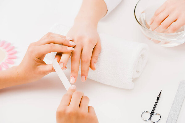 Cropped view of manicurist filing nails with nail file