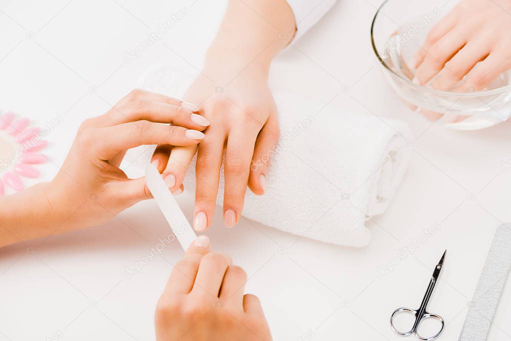 Cropped view of manicurist filing nails with nail file