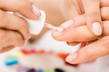 Partial shot of manicurist applying nail polish clipart