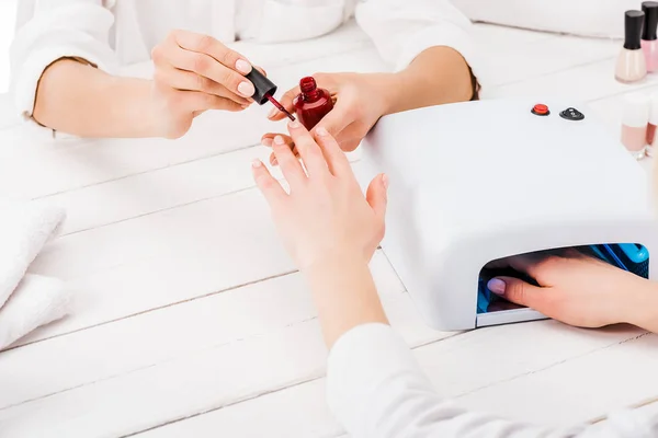 Gedeeltelijke Weergave Van Vrouw Droogt Nagellak Terwijl Manicure Schilderij Vingers — Stockfoto