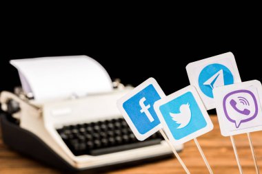 selective focus of facebook, twitter, viber and telegram icons with typewriter on background clipart