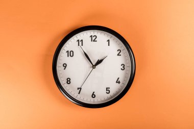 top view of round clock isolated on orange clipart