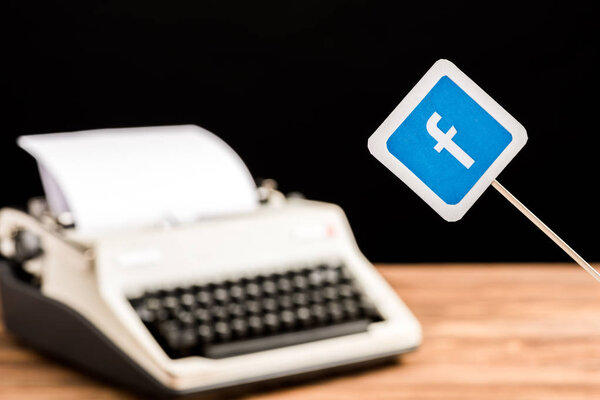 selective focus of facebook website icon with typewriter on background