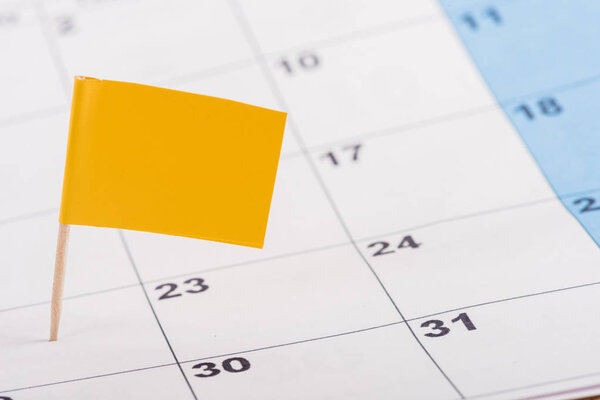 selective focus of yellow flag on number 22 in calendar