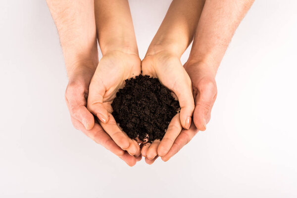 cropped view of woman and man holding soil isolated on white, earth day concept