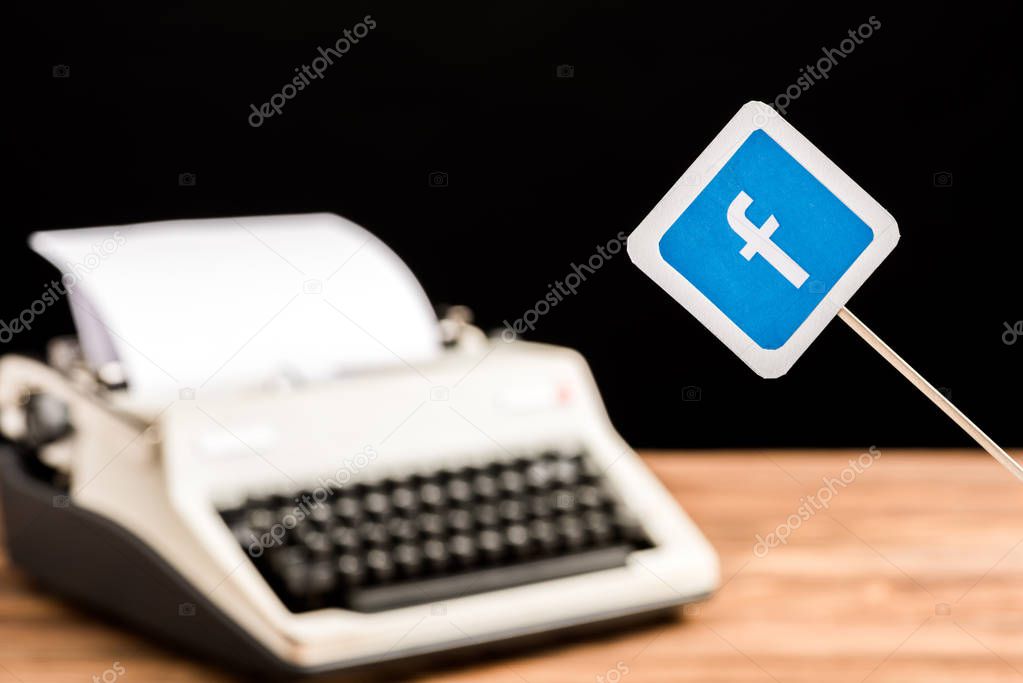 Selective focus of facebook website icon with typewriter on background