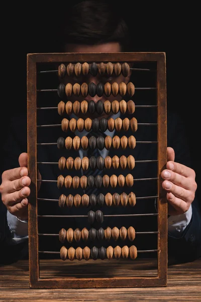 Affärsman Holding Abacus Och Tittar Kameran När Sitter Träbord — Stockfoto