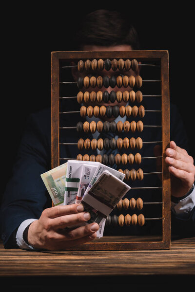 businessman holding russian rubles banknotes and hiding face behind counting frame