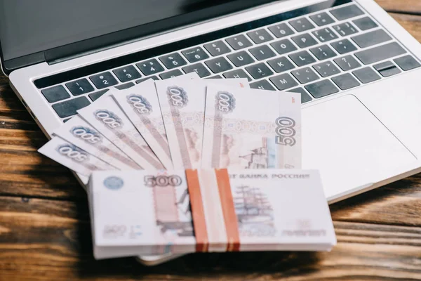 在笔记本电脑键盘上的俄罗斯卢布钞票的特写视图 — 图库照片