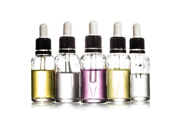 Studio shot of cosmetic bottles with colorful liquid isolated on white clipart