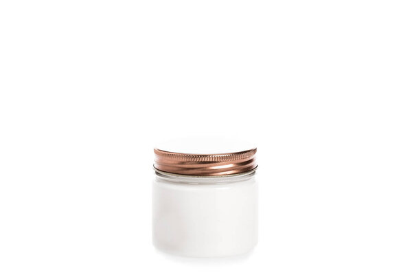 Studio shot of cream in container with metal cap isolated on white