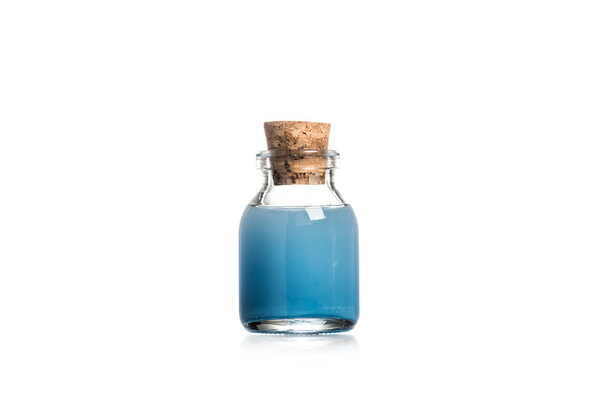 Studio shot of glass bottle with blue liquid isolated on white