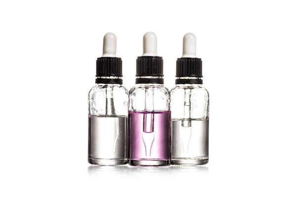 Студийный снимок трех стеклянных бутылок с сывороткой, изолированной на белом
