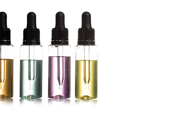 Студийный снимок цветной сыворотки в бутылках с капсулой, изолированной на белом
