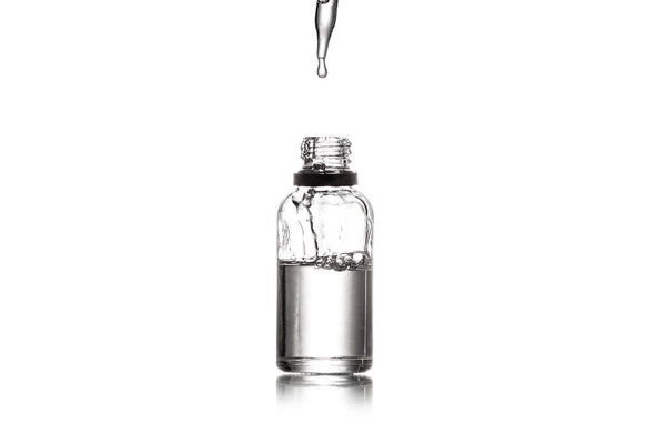 Studio shot of serum bottle with pipette isolated on white