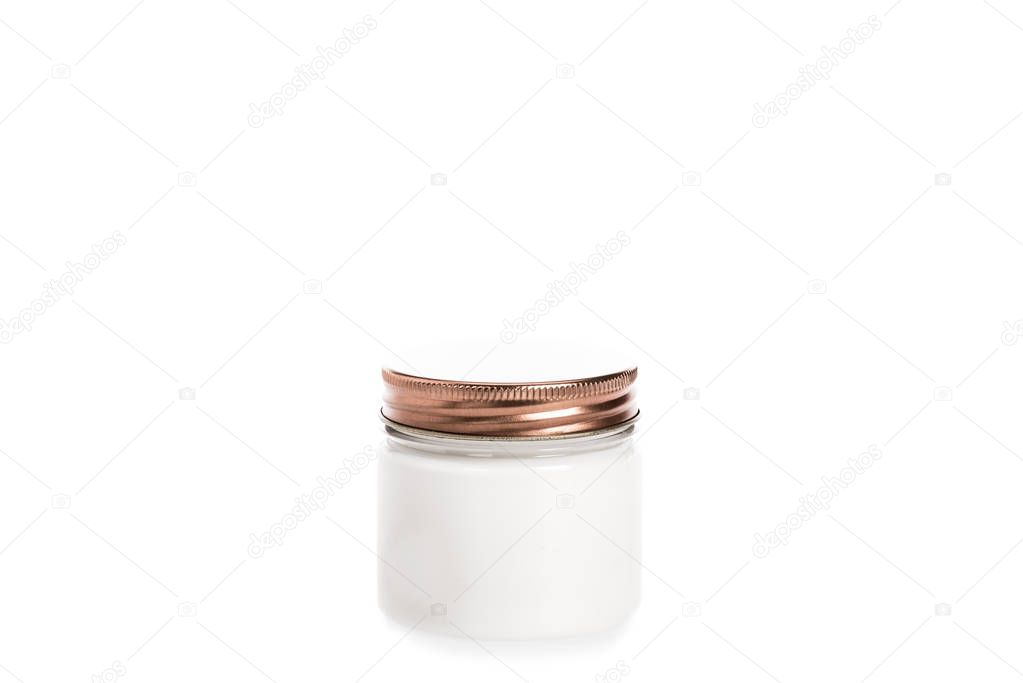 Studio shot of cream in container with metal cap isolated on white