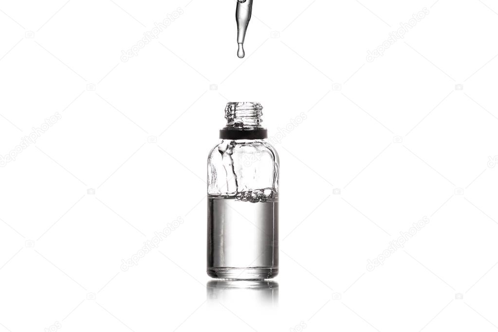 Studio shot of serum bottle with pipette isolated on white