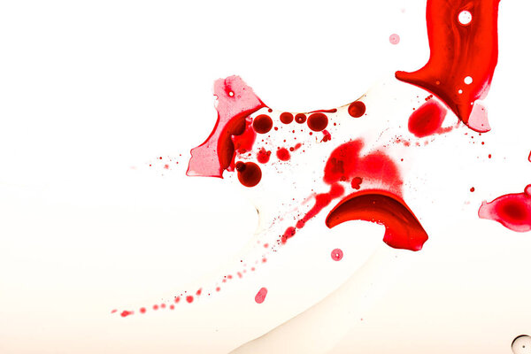 Студийный снимок пятен крови и капель на белой поверхности
