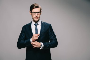 yakışıklı işadamı takım gri arka plan üzerinde duran 