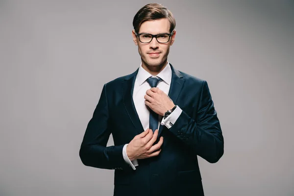 Handsome Businessman Suit Touching Tie Grey Background — Stock Photo, Image