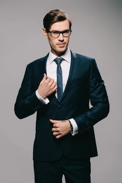 Guapo Hombre Negocios Tocando Chaqueta Sobre Fondo Gris —  Fotos de Stock