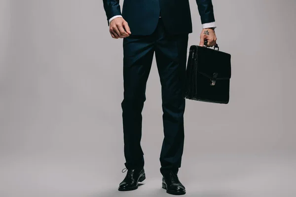 灰色の背景にブリーフケースを保持している実業家のトリミング ビュー — ストック写真