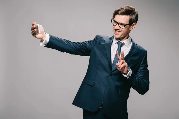 Fröhlicher Geschäftsmann Macht Selfie Und Zeigt Stückschild Auf Grauem Hintergrund — Stockfoto
