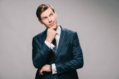 gri arka plan üzerinde elbise düşüncesinde dalgın işadamı 