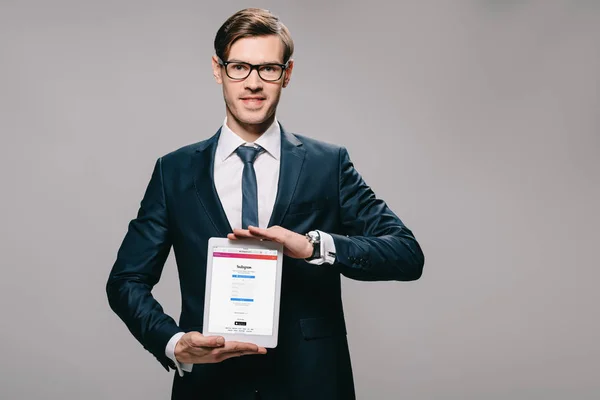 Cheerful Businessman Holding Digital Tablet Instagram App Screen Isolated Grey — Stock Photo, Image