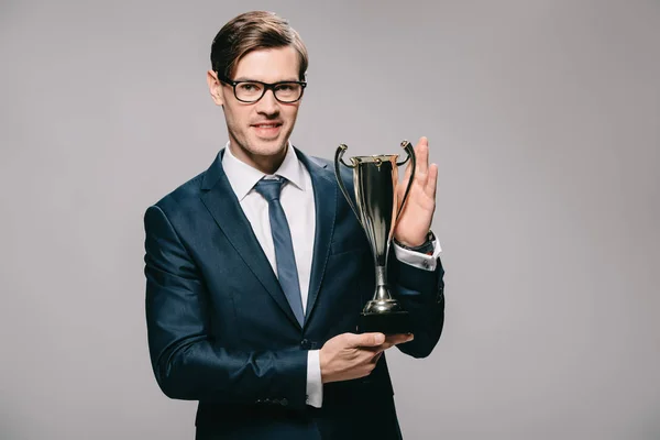 Schöner Geschäftsmann Mit Trophäe Der Hand Isoliert Auf Grau — Stockfoto