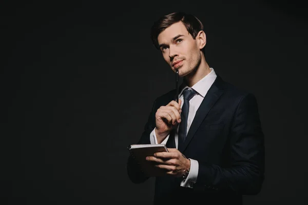 Knappe Zakenman Holding Notebook Met Pen Geïsoleerd Zwart — Stockfoto