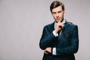 dalgın işadamı izole gri takım elbiseli gözlük dururken holding