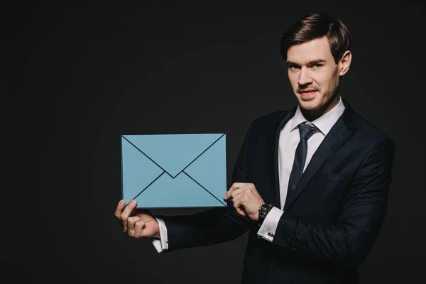 Bonito Empresário Segurando Azul Envelope Isolado Preto — Fotografia de Stock