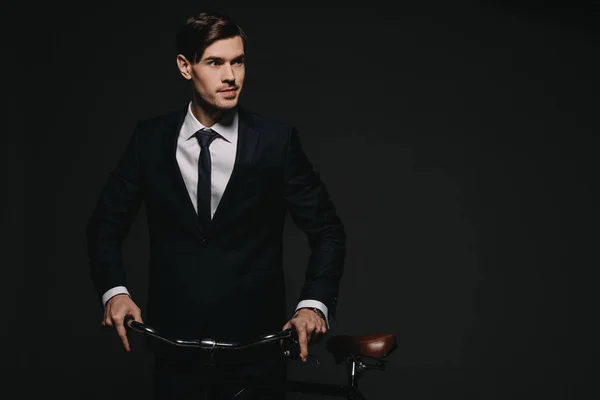 Guapo Hombre Negocios Traje Sosteniendo Bicicleta Aislado Negro —  Fotos de Stock