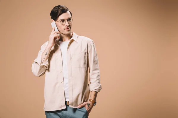 Homem Bonito Óculos Falando Smartphone Enquanto Isolado Bege — Fotografia de Stock
