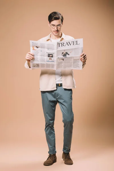 Schöner Mann Liest Reisezeitung Auf Beigem Hintergrund — Stockfoto