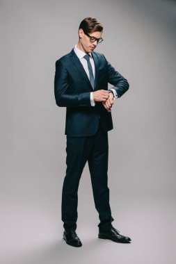 kendine güvenen adam gri arka plan üzerine bakarak takım elbiseli 