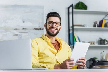 Office kameraya bakarak bardaklarda neşeli işadamı