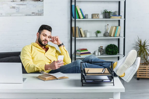Przemyślane Brodaty Biznesmen Żółta Koszulka Patrząc Smartphone Miejscu Pracy — Zdjęcie stockowe