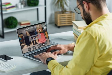 sakallı adam modern ofis ekranda online rezervasyon web sitesi ile Laptop arıyorum