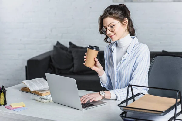 Atractiva Empresaria Sosteniendo Una Taza Papel Mirando Pantalla Del Portátil — Foto de Stock