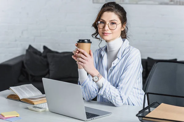 Empresária Atraente Segurando Copo Papel Usando Laptop Olhando Para Câmera — Fotografia de Stock