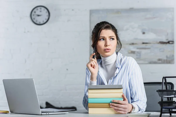 Nachdenkliche Frau Hält Stift Der Hand Und Sitzt Neben Büchern — Stockfoto