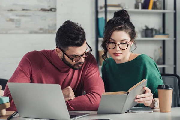 Compañeros Trabajo Gafas Estudio Con Libro Cerca Computadora Portátil Oficina — Foto de Stock