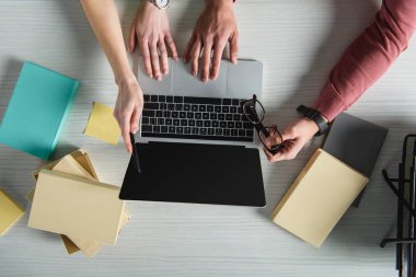kadın gözlük tutan adam yakınındaki boş ekran ile laptop işaret görünümünü kırpılmış