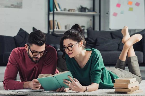 Vrolijke Paar Glazen Liggen Tapijt Lezen Van Boek — Stockfoto